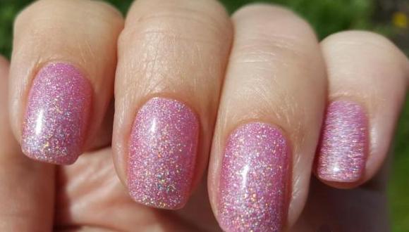 Smalto gel per manicure delicatamente rosa con scintillii, sfregamenti, strass, argento, nero, bianco, blu, oro. Una foto