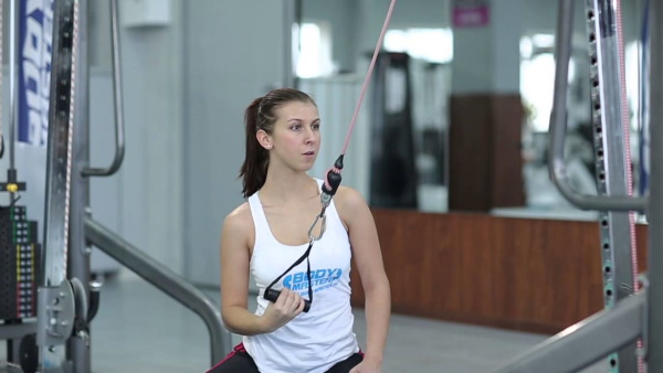 Exercise machine vertical pull. Technique for sitting, on the back, behind the head, with a narrow grip for women