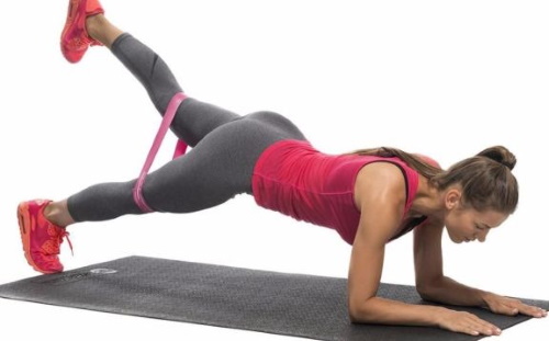 Exercises with an elastic band for the legs and buttocks to a woman sitting on a chair, standing, lying and others