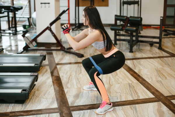 Exercises with an elastic band for the legs and buttocks to a woman sitting on a chair, standing, lying and others